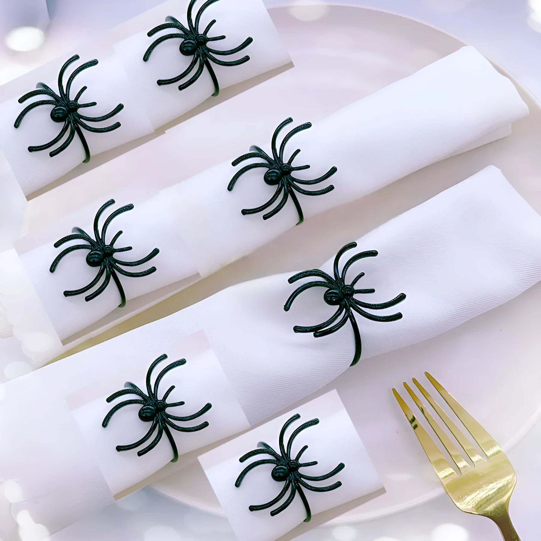 Six black alloy spider-shaped napkin rings for Halloween table settings.