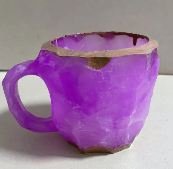 Purple and blue resin coffee mug with crystal texture and handle on wooden table