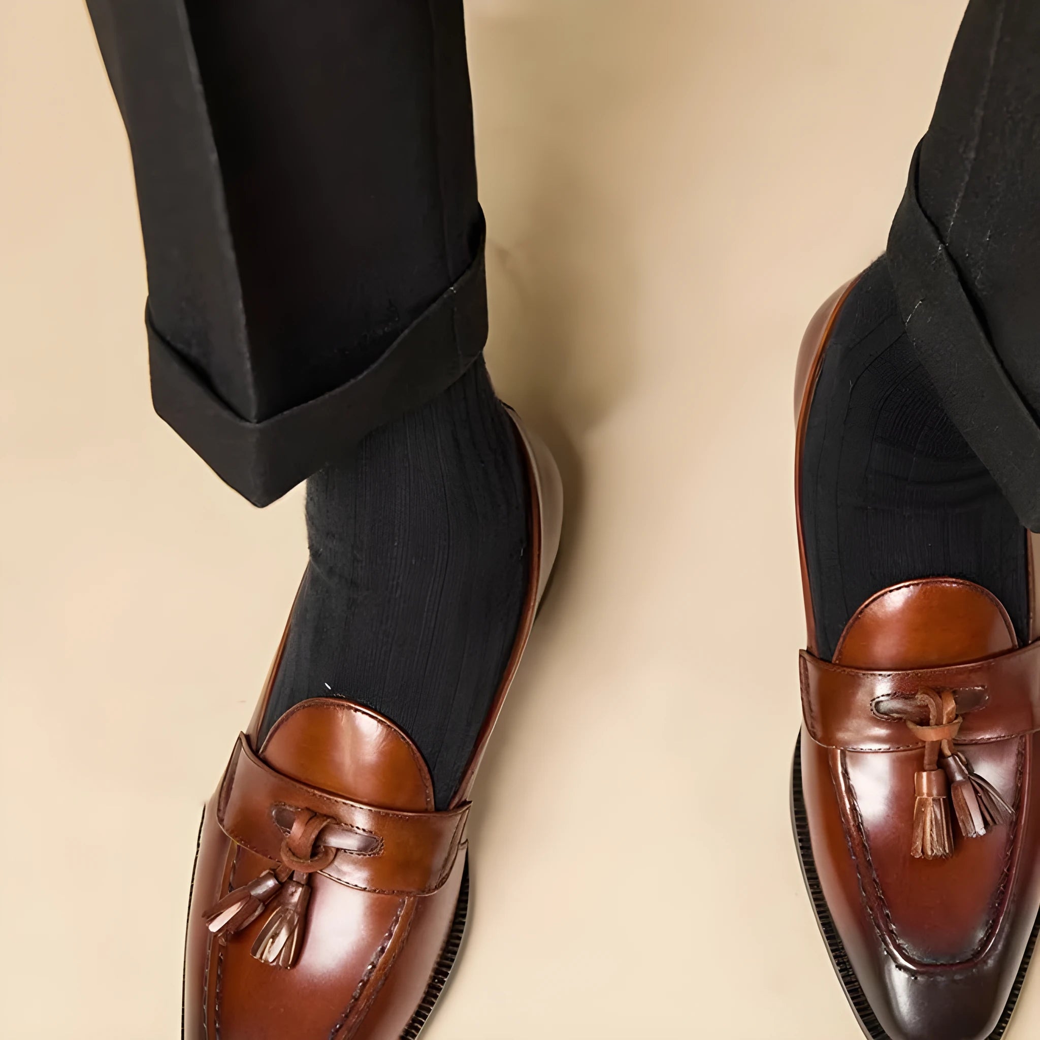 Men's black leather tassel loafers with polished finish and rubber soles for business casual wear