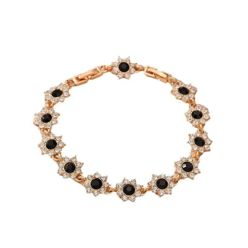 Electroplated zinc alloy bracelet with flower-shaped coloured gems in gold or silver tone.