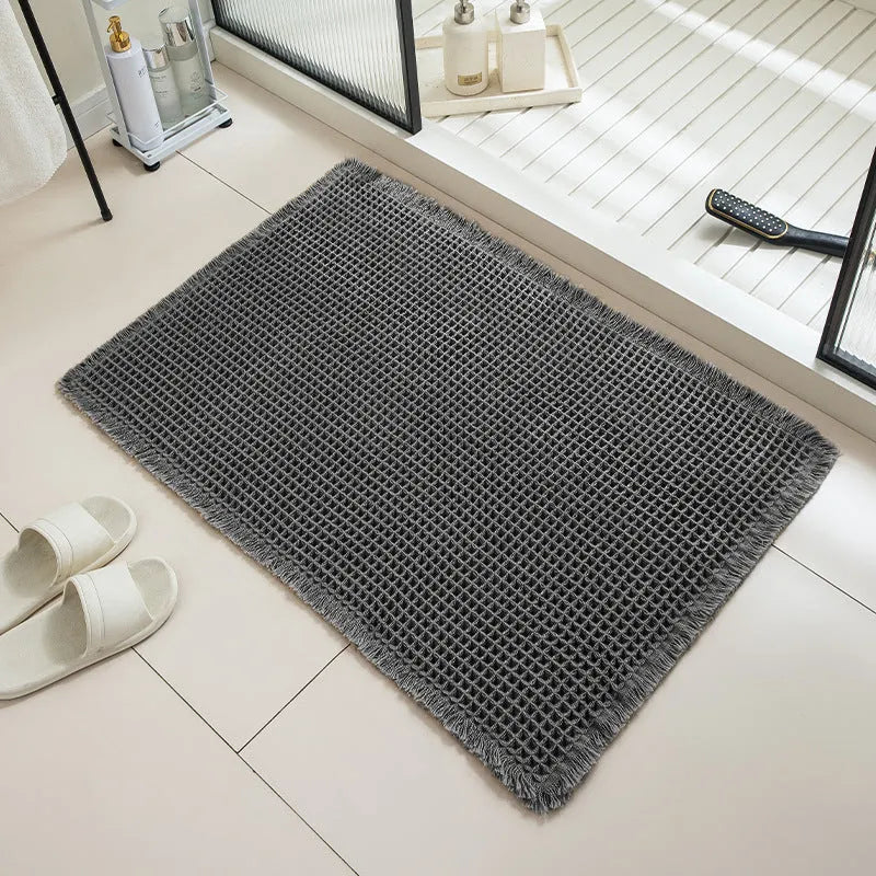 Square checkered pattern bathroom carpet on tiled floor in light grey colour.