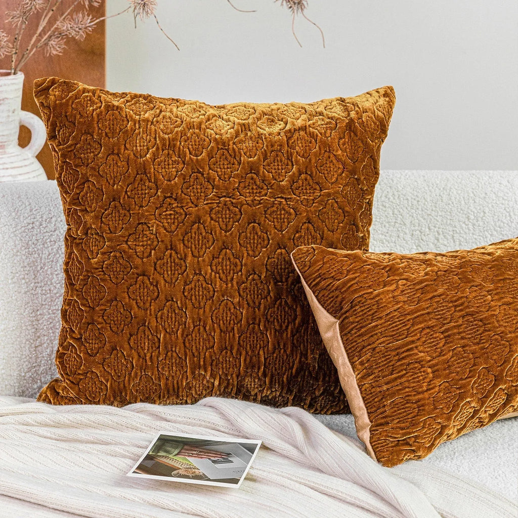 Brown gold antique quilted square cushion pillow on a sofa next to a green waist pillow.