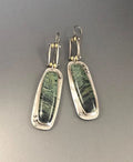 Geometric alloy earrings with a white and grey marble pattern on a simple background.