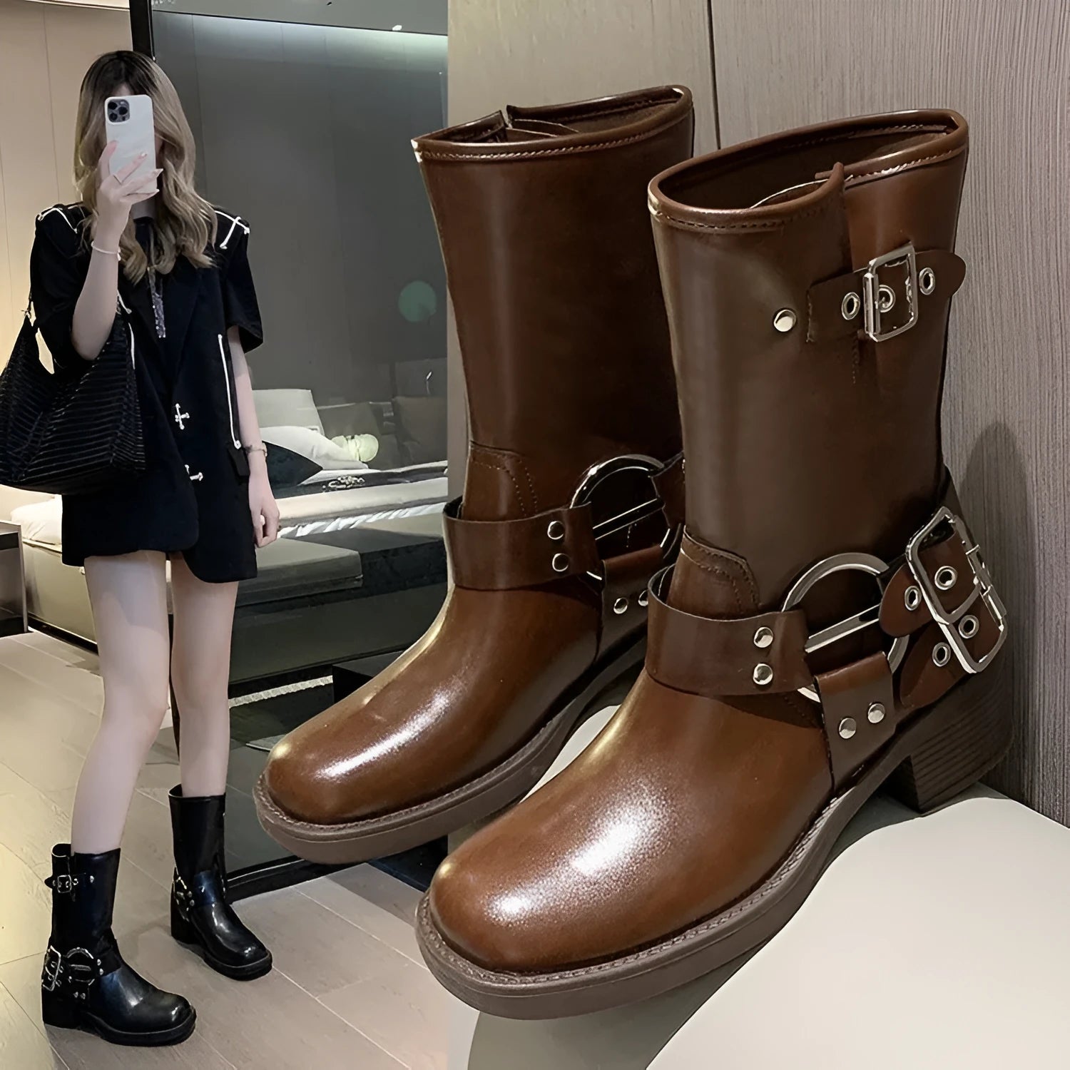 Women's black leather platform boots with a silver belt buckle, shown from the side.