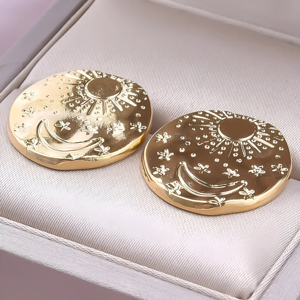 A pair of geometric shell design stud earrings in stainless steel with a gold or silver finish.
