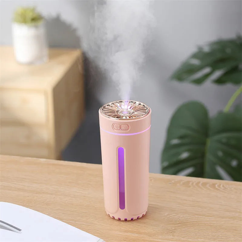 Compact black wireless humidifier with colourful LED lights sitting in car cup holder