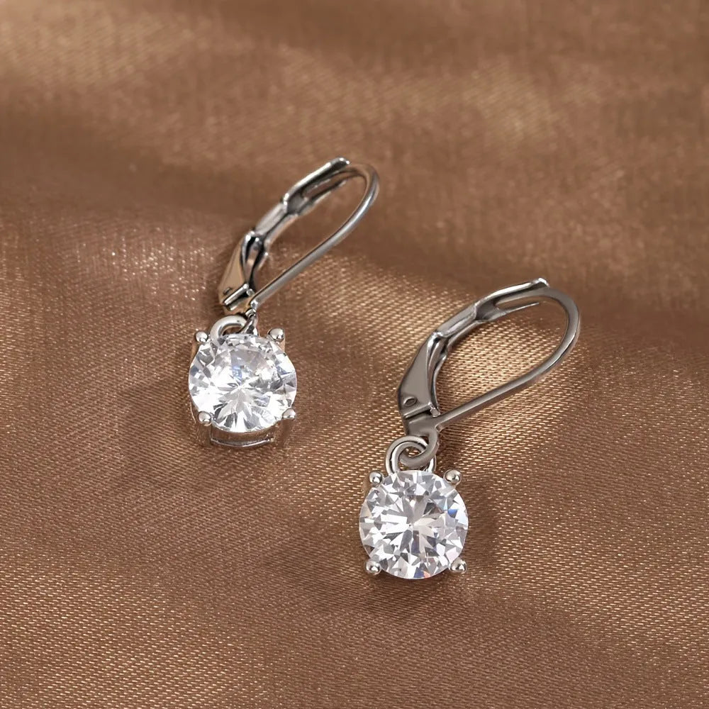 Silver colour zircon earrings with genuine stones and secure metal fastening on a white background