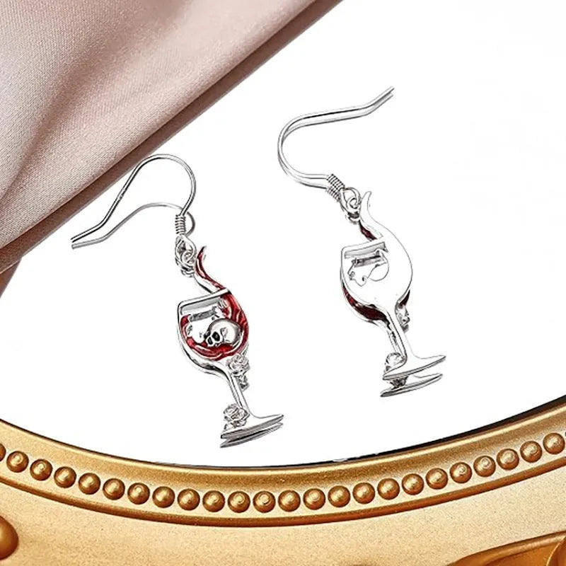 A pair of geometric skull wine glass shaped earrings with an electroplated finish.