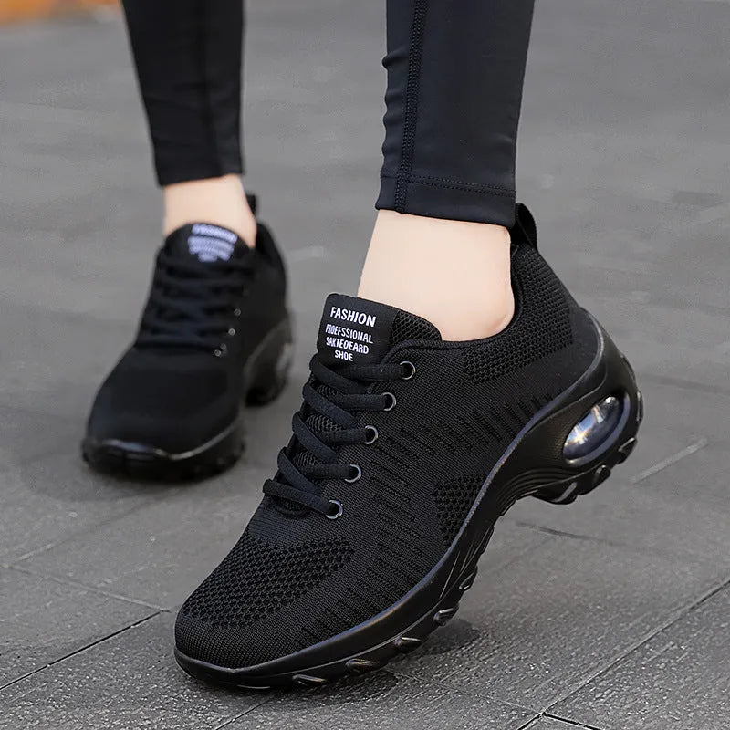 Women's red and black round toe lace-up mesh sneakers with low top and flat mid heel.