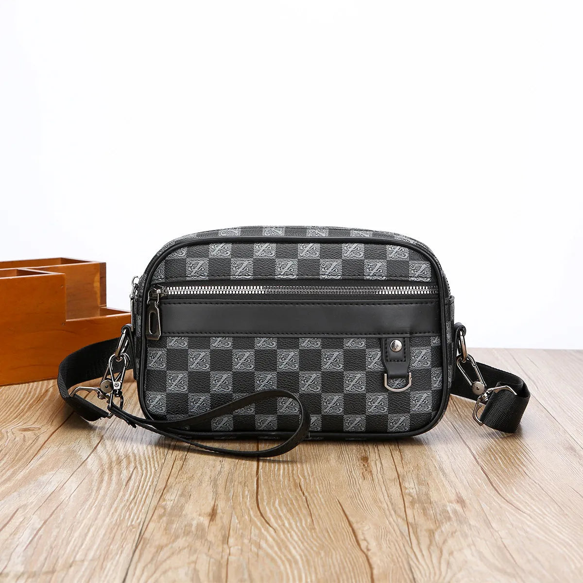 Men's black casual shoulder messenger bag with geometric pattern, shown with handheld top handle and adjustable shoulder strap.
