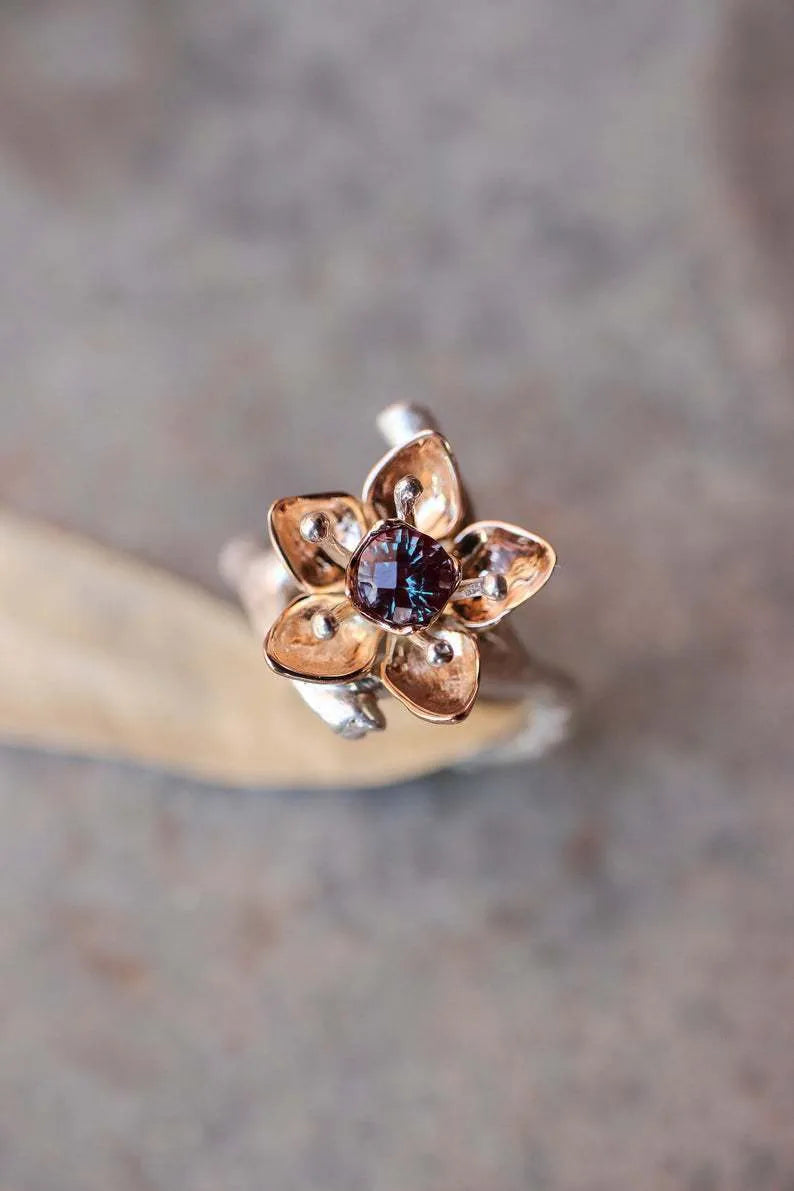 Silver two-tone alloy ring with geometric floral design on a white background.