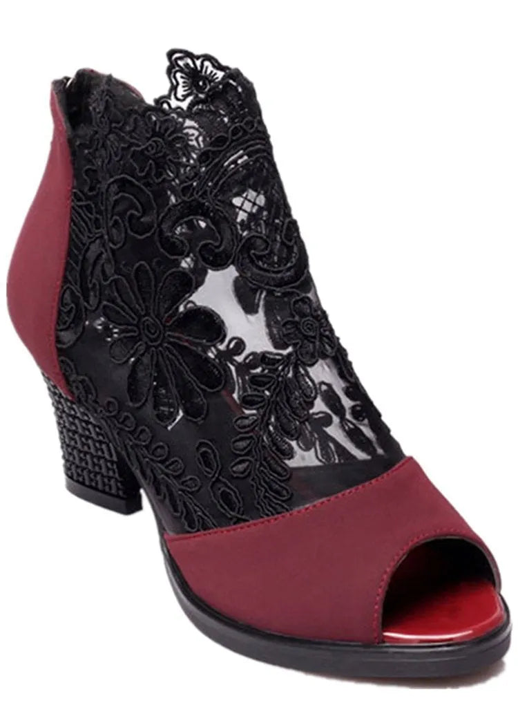 Women's black lace-up gladiator sandals with a square high heel and decorative floral detail on the peep toe