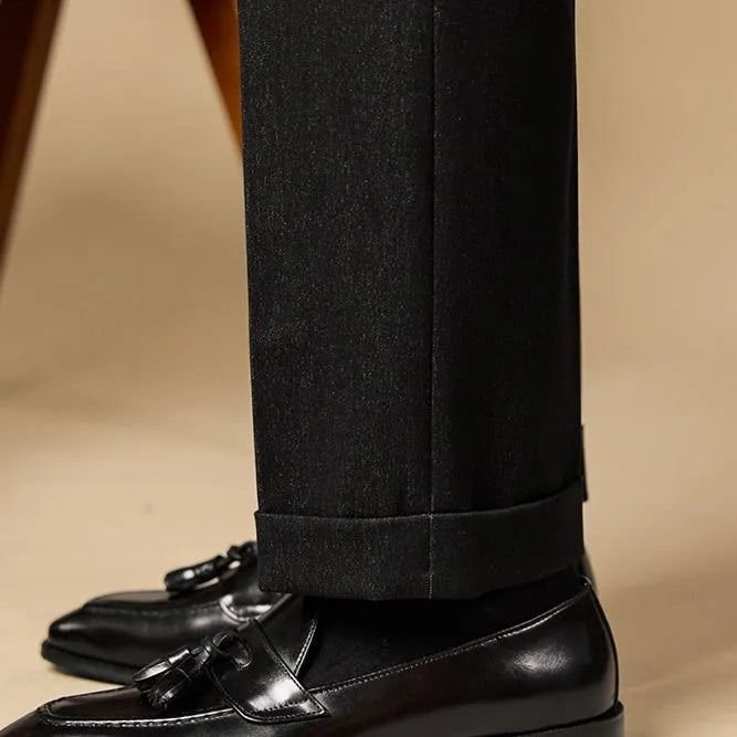 Men's black leather tassel loafers with polished finish and rubber soles for business casual wear
