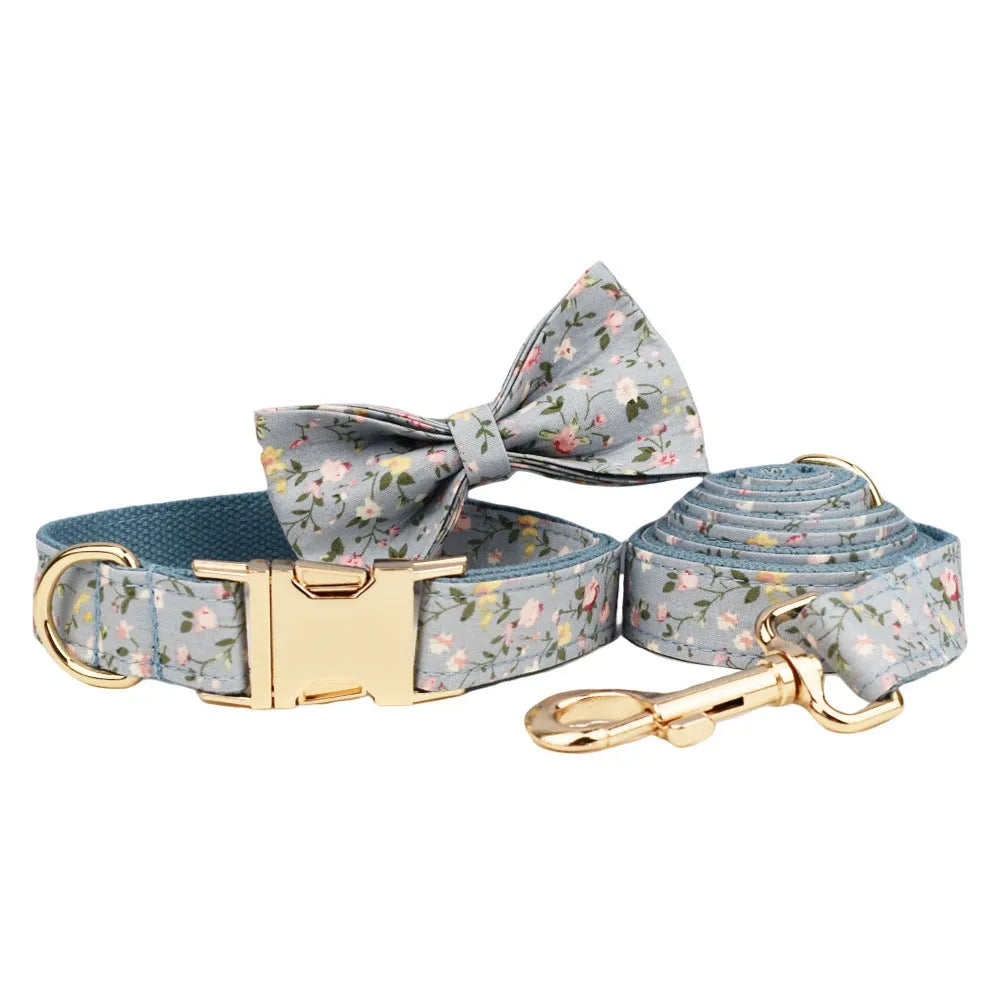 Blue floral patterned cloth dog collar with matching leash and vest set on a white background.