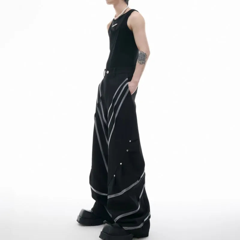 Men's black trousers with three-dimensional cutting and metal rivet pleats on a white background.