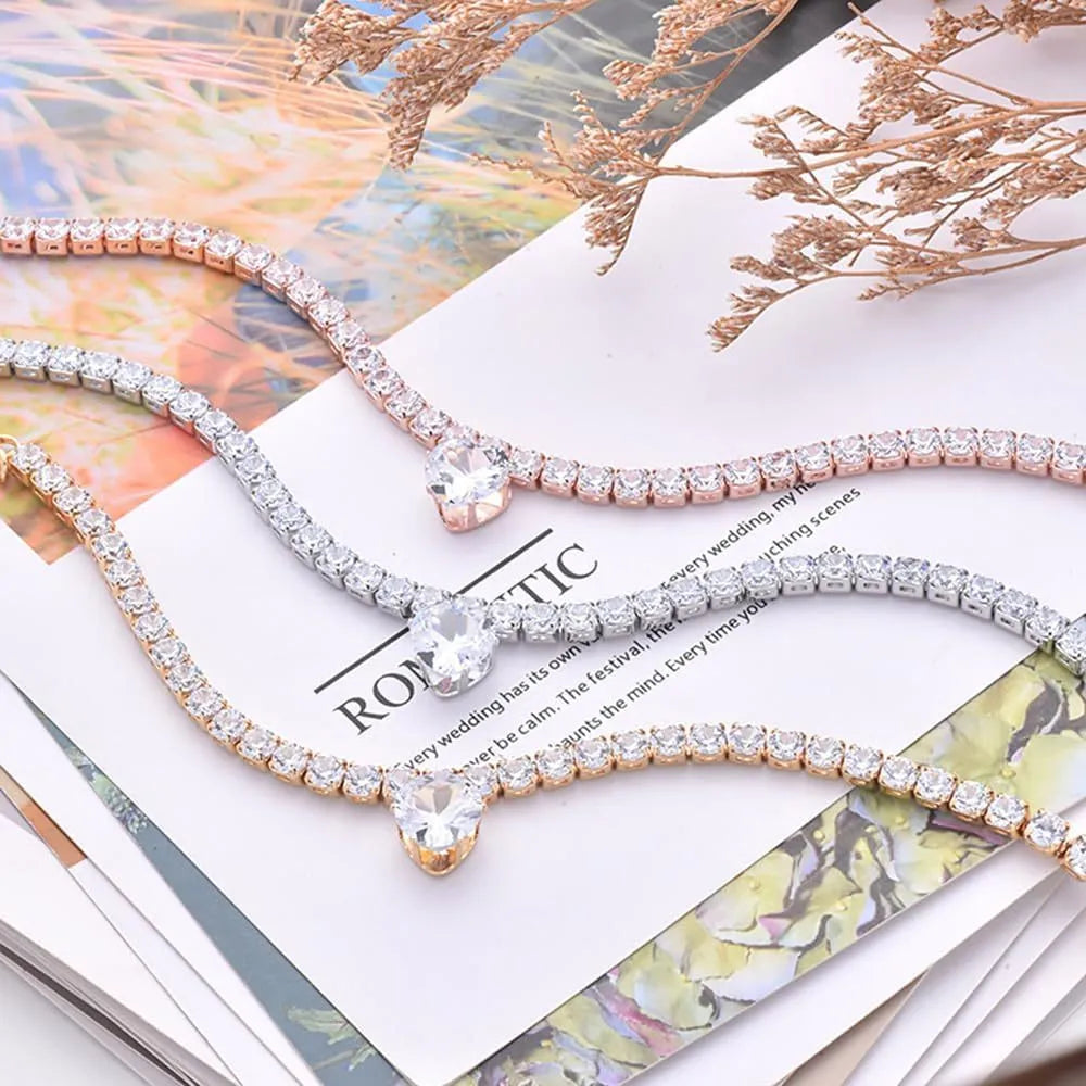 Gold rhinestone heart-shaped decorative collar for a dog or cat on a white background.
