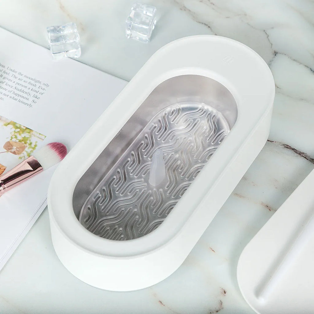 White portable ultrasonic cleaner with digital display and stainless steel cleaning tank.
