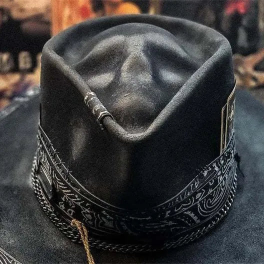 Handmade wool felt skull hat with a pointed conical crown on a neutral background