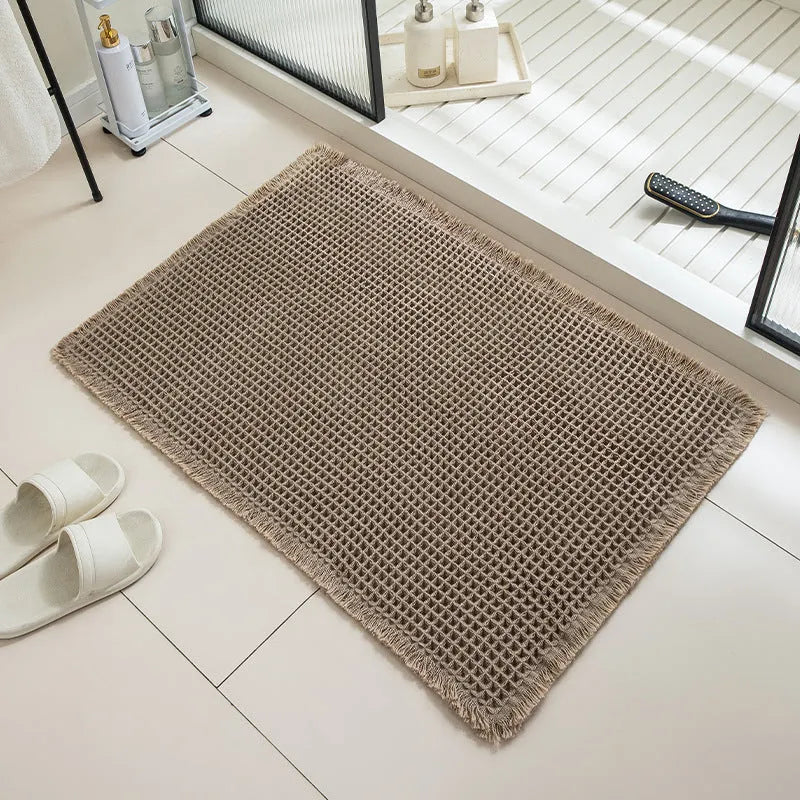 Square checkered pattern bathroom carpet on tiled floor in light grey colour.