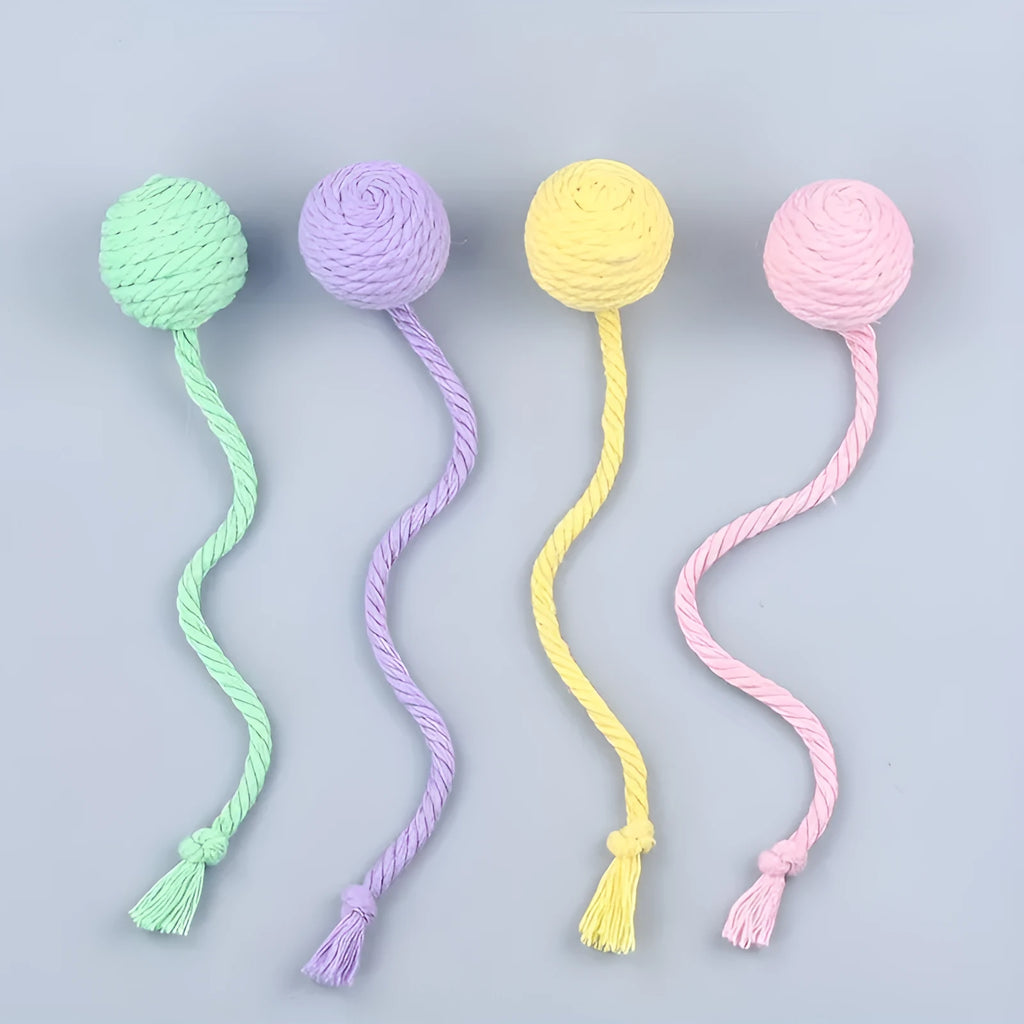 Green and pink plastic cat toy balls with ropes and internal bells.