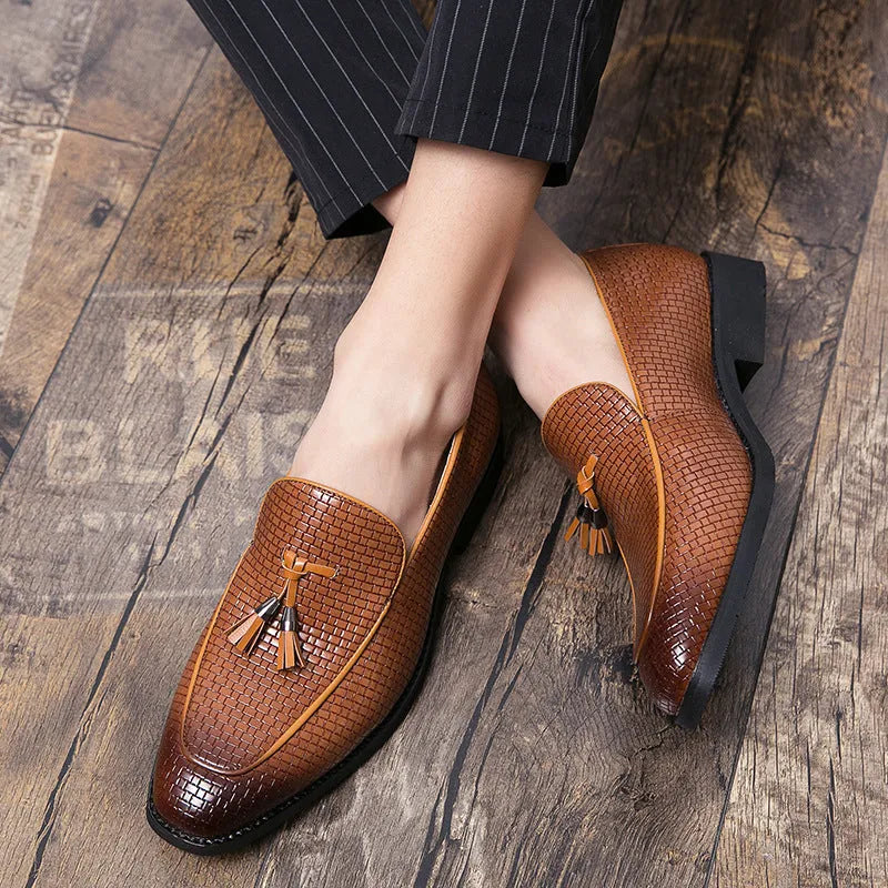 Men's black pointed toe slip-on business shoes with a tassel decoration on the front.