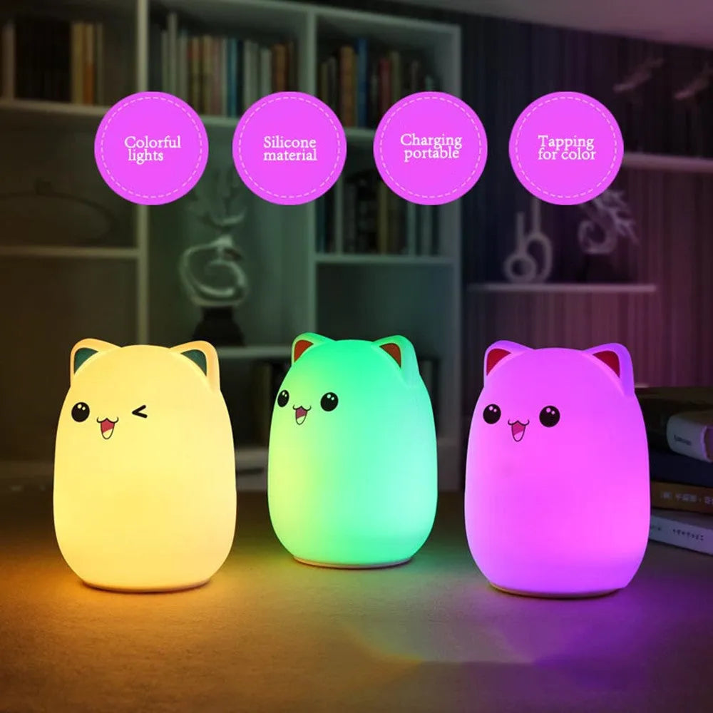 Cartoon silicone clap lamp in blue with warm white light mode on a wooden bedside table