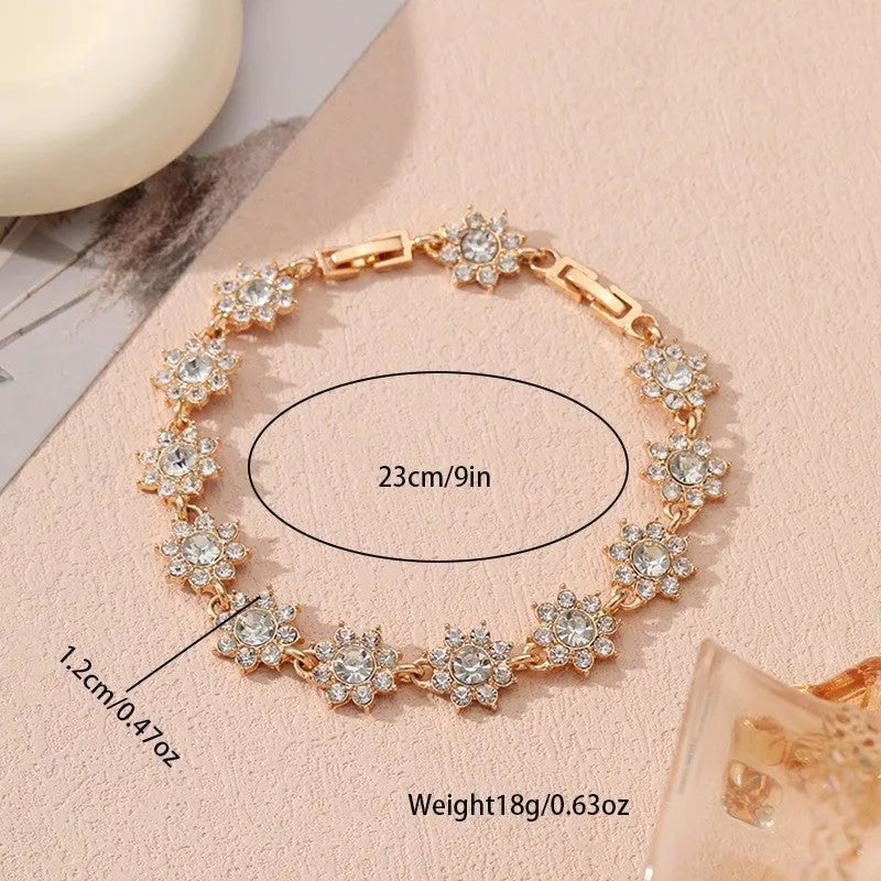 Electroplated zinc alloy bracelet with flower-shaped coloured gems in gold or silver tone.