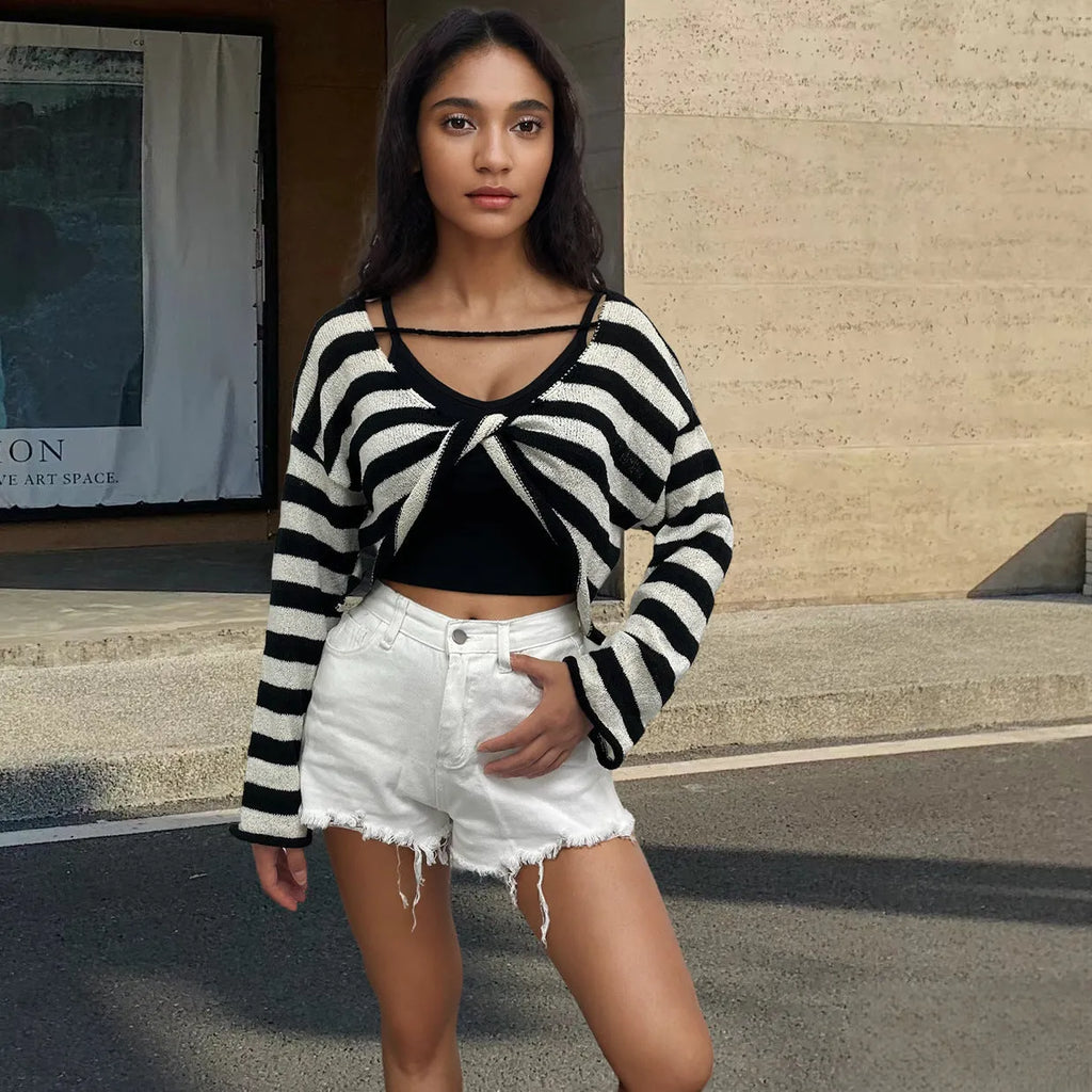 Woman wearing a striped cropped long-sleeved sweater in coloured cotton, showcasing the front and back wearable design.