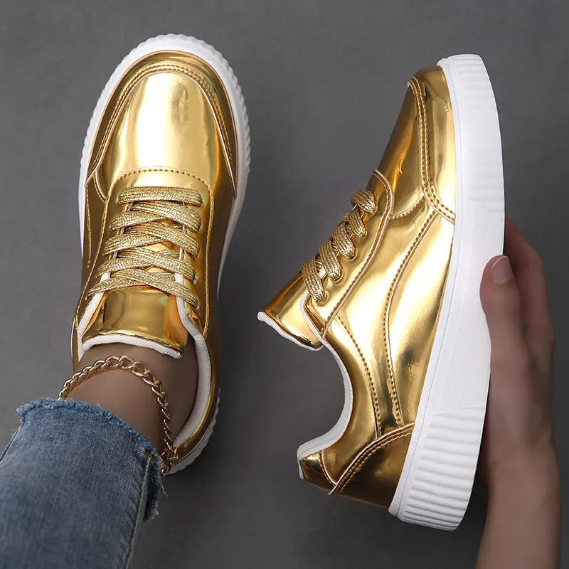 Gold sequinned platform sneakers with thick sole and round toe on a neutral background.