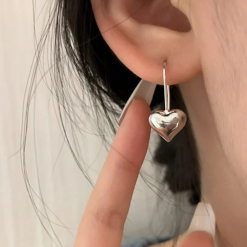 Korean style heart-shaped earrings with glossy finish and silver colour