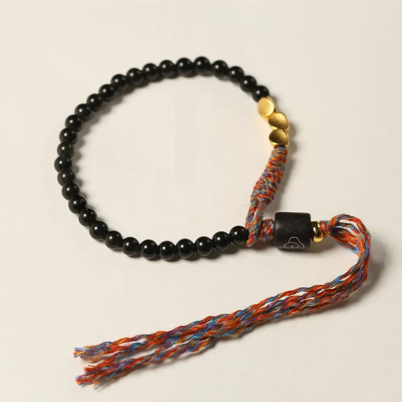Hand-woven obsidian bracelet with dark beads showing woven texture and adjustable 15.5-16cm length