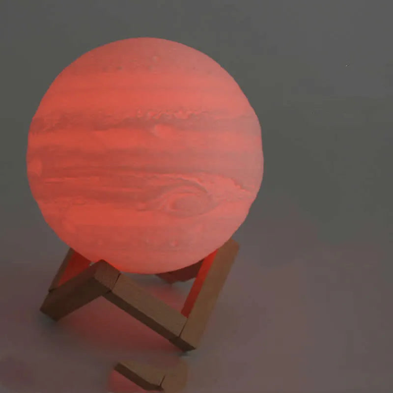 3D printed moon lamp glowing on a wooden stand with touch ring at base