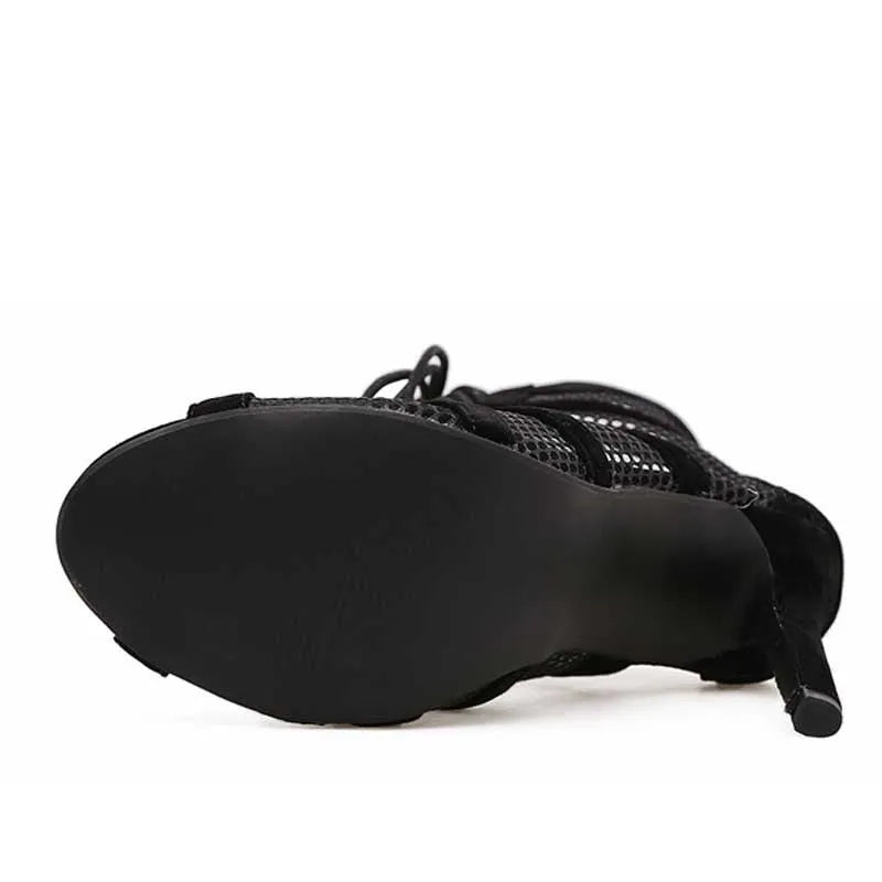 Black suede women's lace-up high heel shoes with a high heel on a plain background.
