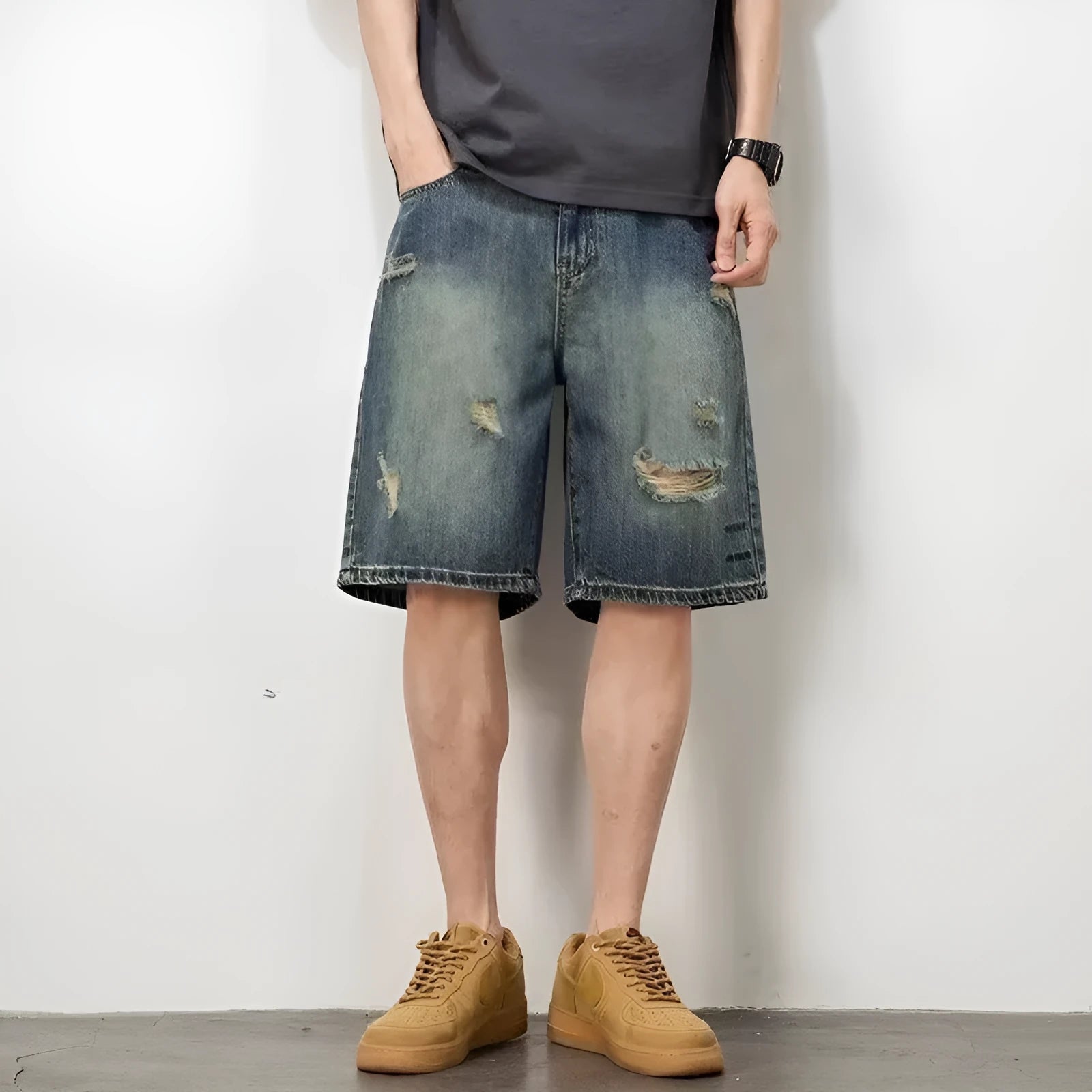 Man wearing blue retro loose-hole denim shorts with a straight leg cut on a casual background.