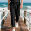Man wearing light khaki straight-leg linen trousers with a drawstring waist.