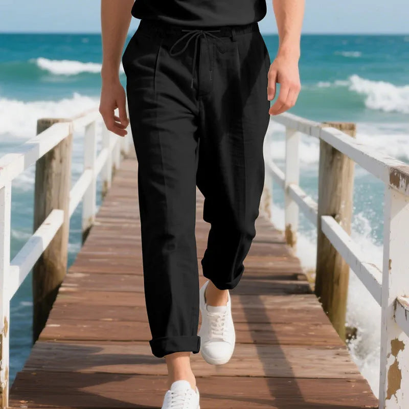 Man wearing light khaki straight-leg linen trousers with a drawstring waist.