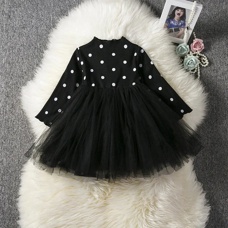 Baby girl in a long sleeve pink tutu dress with lace detailing on the sleeves.