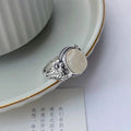 Adjustable copper vintage ring with imitation white chalcedony stone on a U-shaped band.