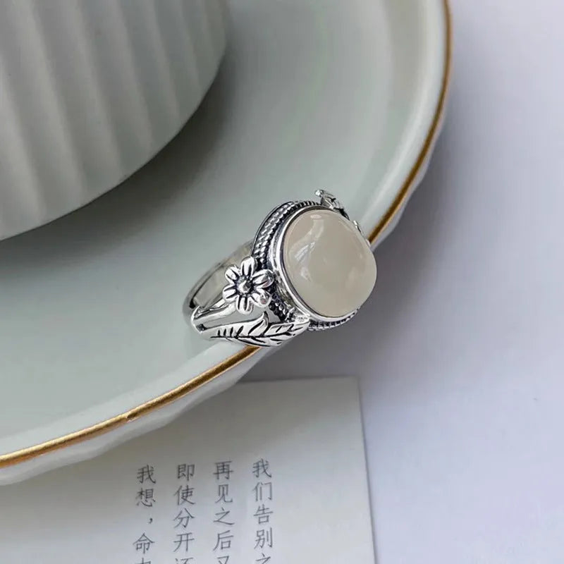 Adjustable copper vintage ring with imitation white chalcedony stone on a U-shaped band.