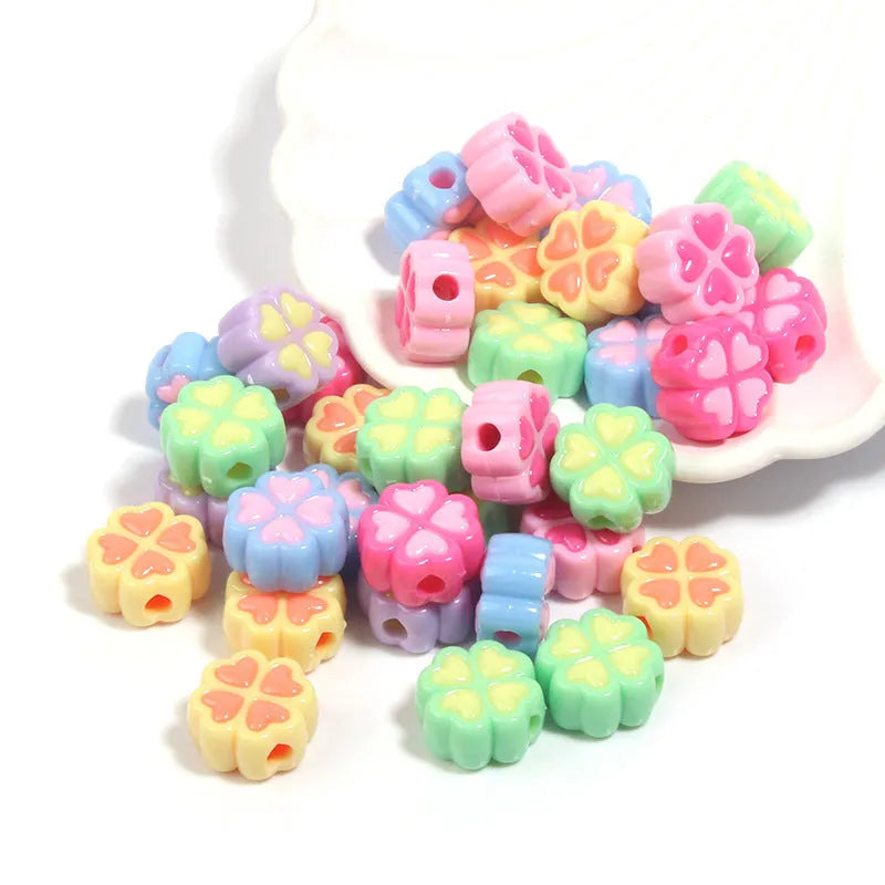 Mixed colour frosted acrylic four-leaf clover shaped beads, each 15mm in size.