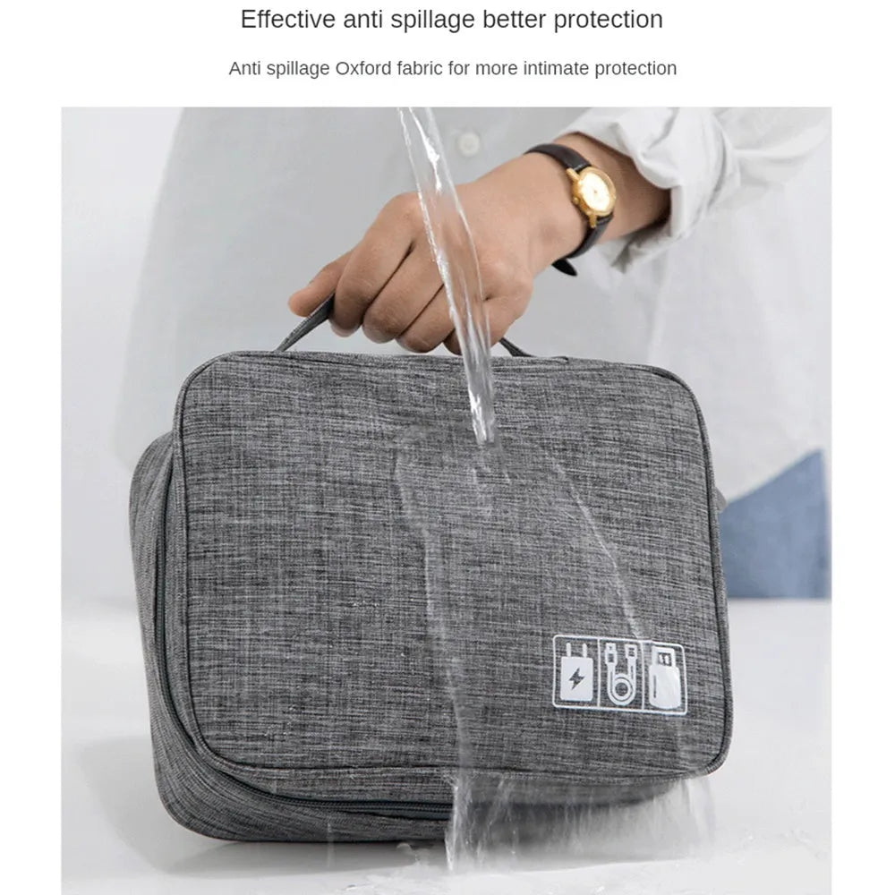Black waterproof electronics organiser bag open to show mesh pockets, elastic loops and removable padded dividers inside.
