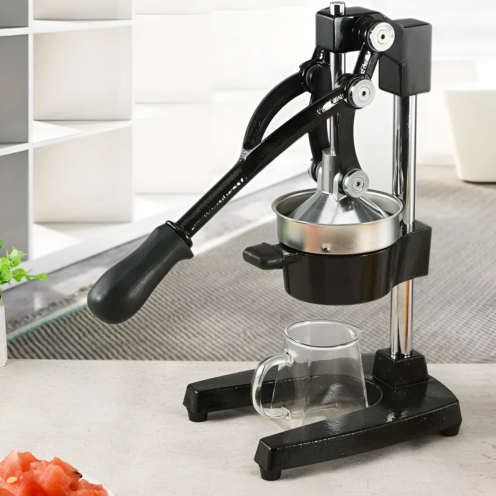 Black and white manual citrus juicer with cast iron base and stainless steel funnel