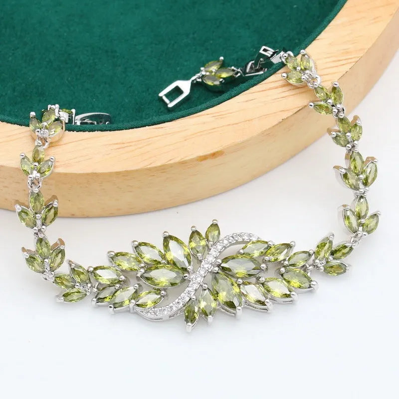 Retro-style jewellery set with necklace, bracelet, earrings, and ring featuring floral patterns in olive and purple colours.