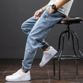 Man wearing loose blue cargo jeans with a straight leg and micro-elastic cotton fabric.