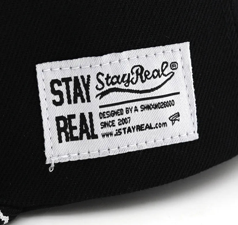 Black cotton baseball hat with white embroidered letters on the front, showing the dome crown shape.