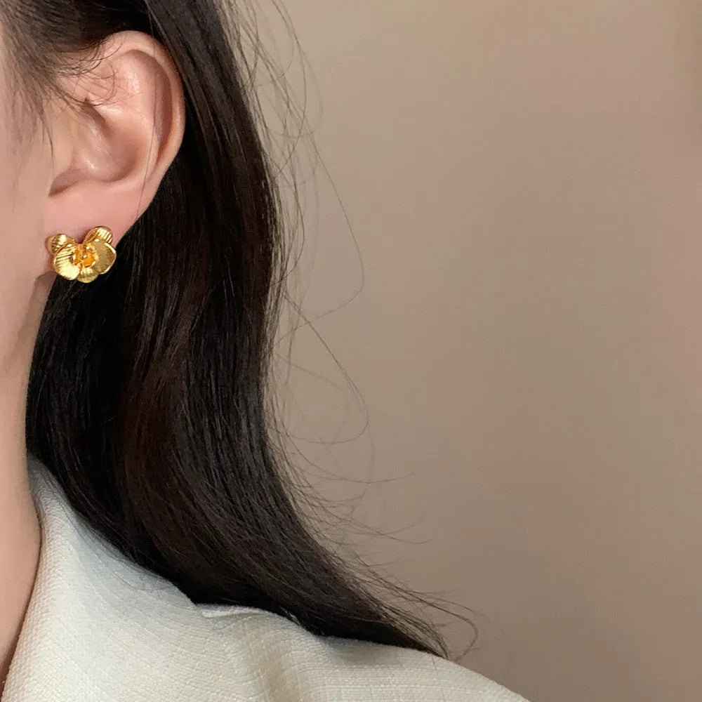 A pair of women's retro-style flower drop earrings with petal details in a gold or silver electroplated finish.
