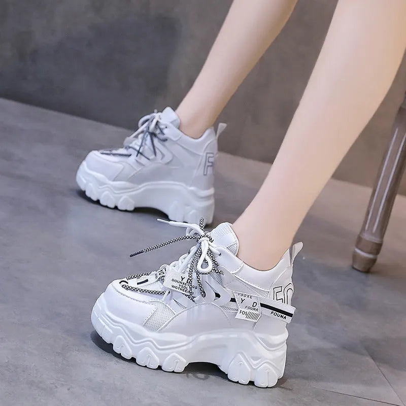Women's white breathable mesh platform sports shoe with a cross strap on a rubber sole
