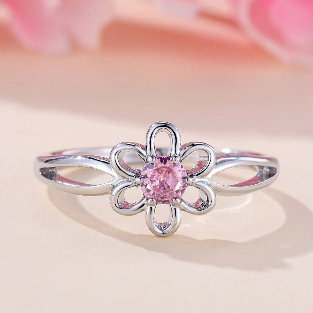 Close-up of a women's hollowed flower ring with a platinum pink diamond electroplated finish.