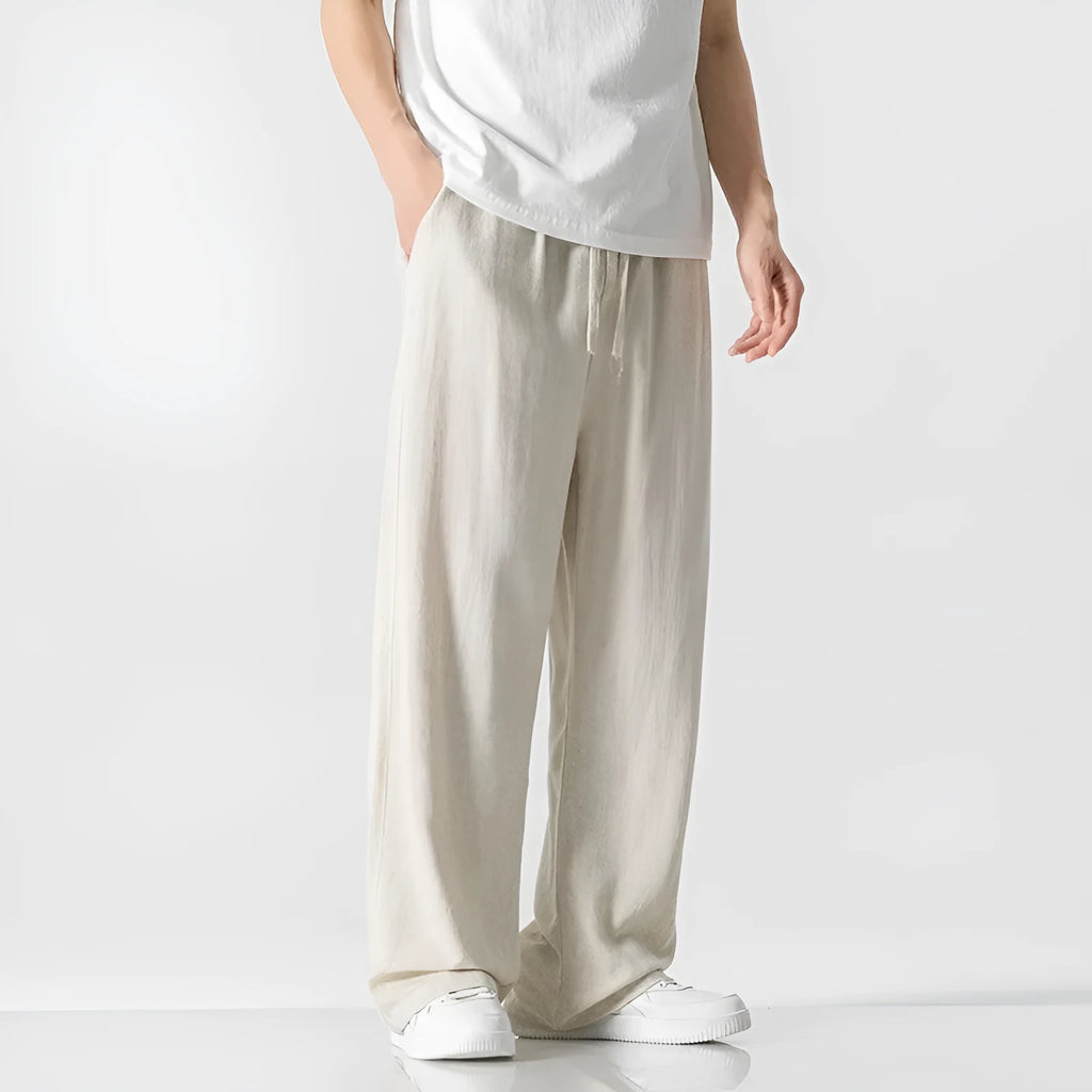 Men's beige bamboo fibre straight-leg cropped trousers with a drawstring waist on a neutral background.