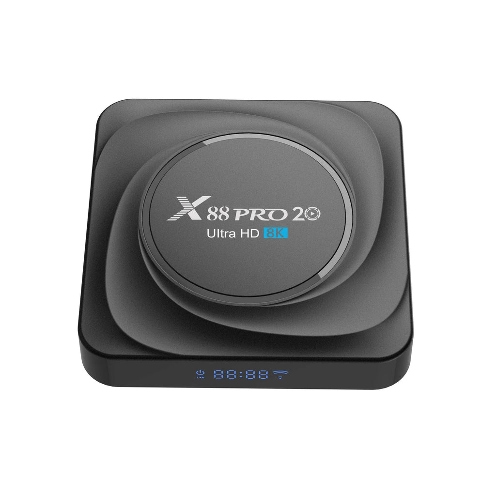 Compact black Android TV set-top box with remote control and HDMI cable on a wooden surface.